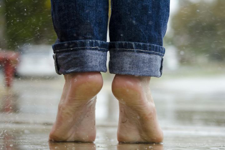 Person in Blue Denim Jeans Standing Outside the Rain