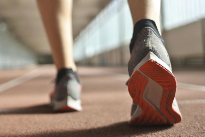 Fit runner standing on racetrack in athletics arena